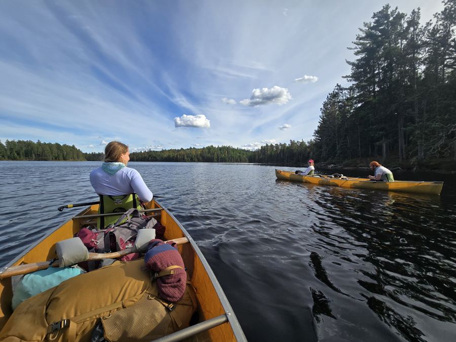 Loaded canoes crossing a wilderness lake